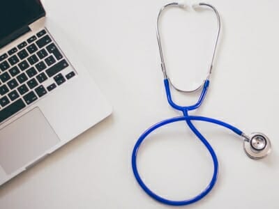 Stethoscope next to a laptop